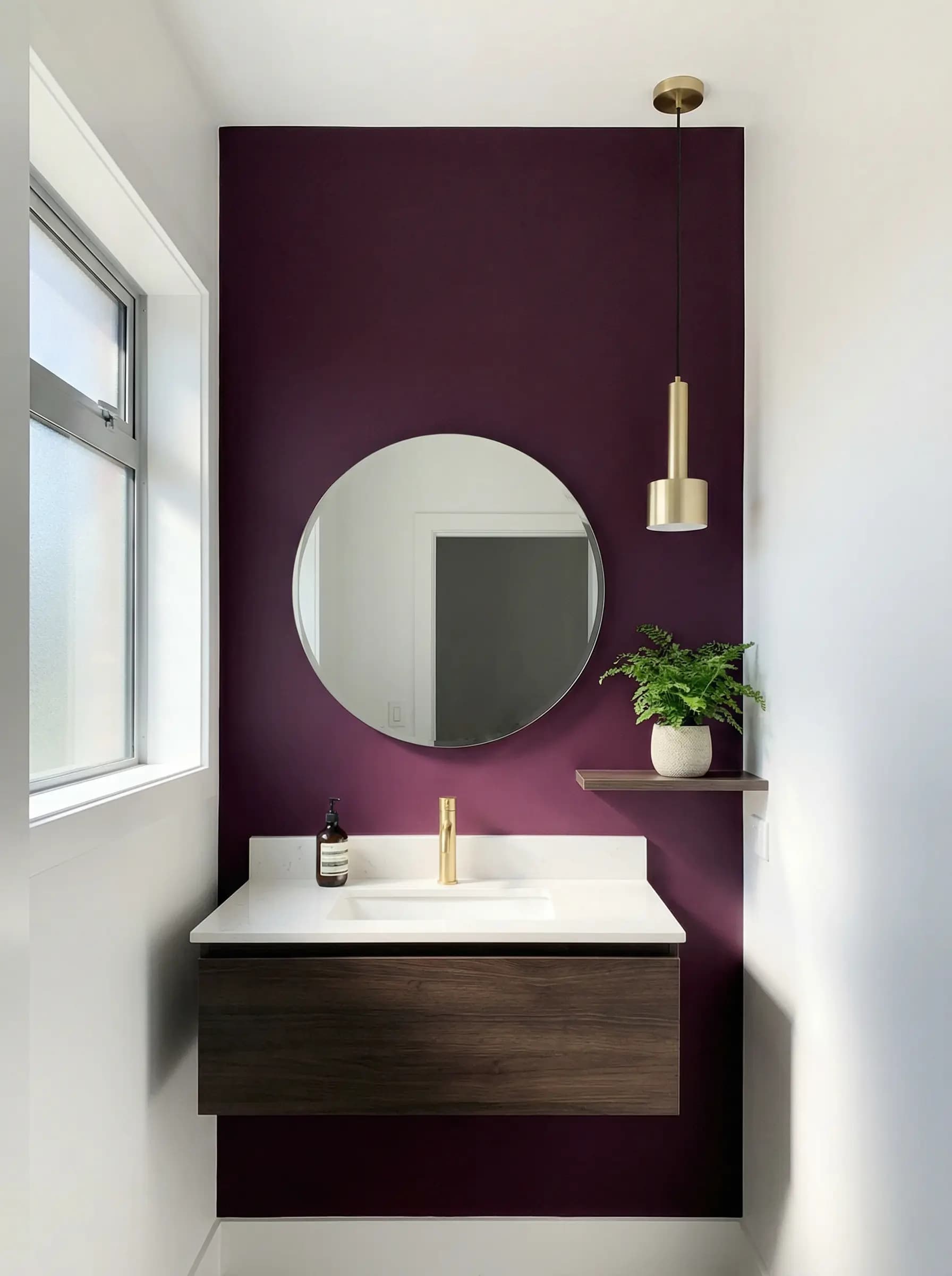 Luxurious powder room finished in a rich plum with polished brass fixtures
